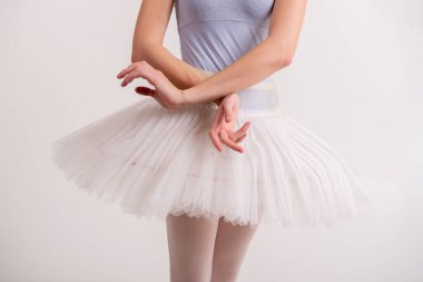 Beyaz saçlı, uzun saçlı, gri mayolu ve bale için beyaz etekli güzel bir kız.