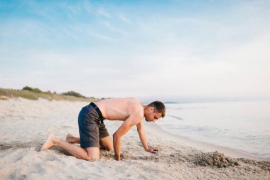 Kumsalda çukur kazan adam.