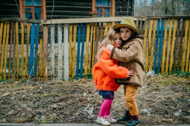 Eski elbiseli iki kız kardeş, sonbahar tatillerinde köydeki büyükannelerinde eğleniyorlar..