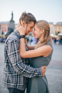 Krakow 'daki merkez meydanında genç ve sevgi dolu bir çift kucaklaşması.)