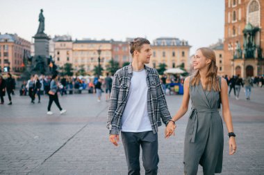 Krakow 'daki merkez meydanında genç ve sevgi dolu bir çift kucaklaşması.)