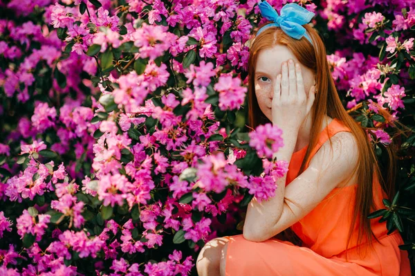 夏のドレスで魅力的な若い女の子の肖像は 植物園で紫色の植物を楽しんでいます — ストック写真