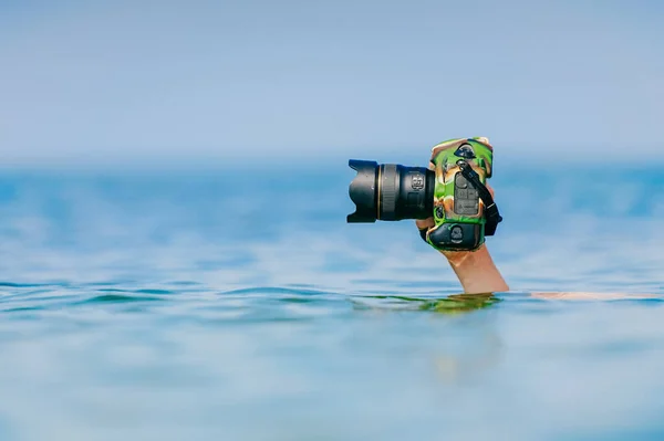 水中で泳いだり 海の水の上で彼の手で乾燥し 安全性のプロのカメラを維持男性ダイバー 深海から写真を撮るクレイジーな写真家 面白いと危険な趣味と仕事 — ストック写真