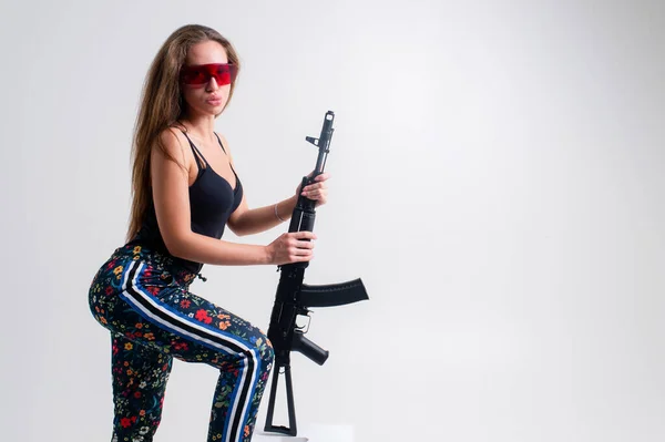 Mulher Caucasiana Futurista Com Rifle Assalto Pernas Cruzadas Fundo Branco — Fotografia de Stock