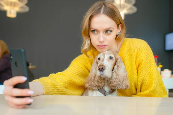 Joven Rubia Alegre Sosteniendo Perro Cocker Spaniel Rodillas Tomando Selfie —  Fotos de Stock