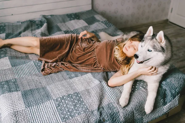 Mladá Dívka Hnědých Šatech Ležící Doma Posteli Spící Husky Štěně — Stock fotografie