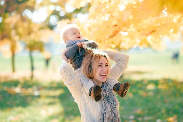 Ung Mor Poserar Med Barn Axlarna Solig Höstpark — Stockfoto