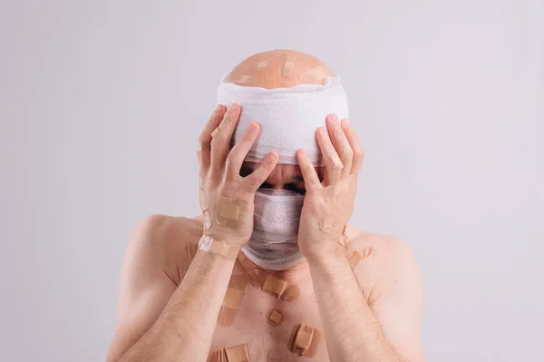 Injured Man Many Patches His Body Bandaged Head Isolated White — Stock Photo, Image