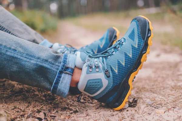 Male legs wearing sportive hiking shoes. Mens legs in trekking boots for outdoor activity.
