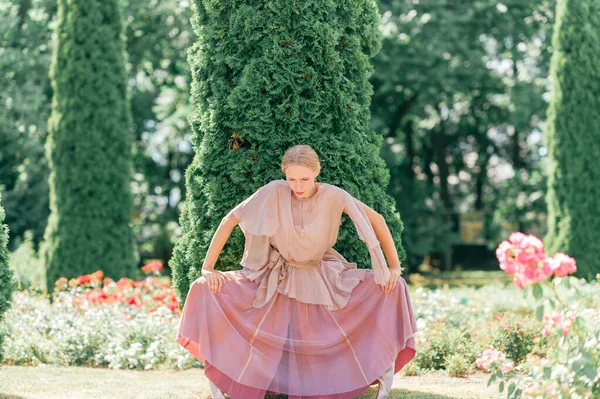 若いです優雅な女性バレエダンサーで劇場ドレスポーズで日当たりの良い公園 — ストック写真