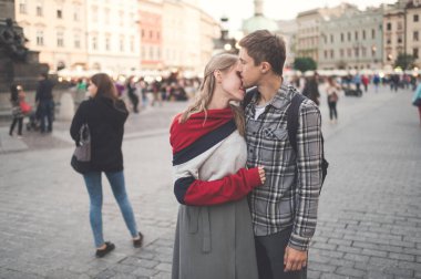 Krakow 'daki merkez meydanında genç ve sevgi dolu bir çift kucaklaşması.)