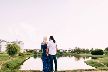 Uzun saçlı bir adam ve ince boylu, uzun mavi elbiseli bir sarışın güneşli bir yaz gününde muhteşem göle bakarlar. Nehre bakan kız ve erkeğin aşk hikayesi. Güzel manzaranın arka planında aşıklar