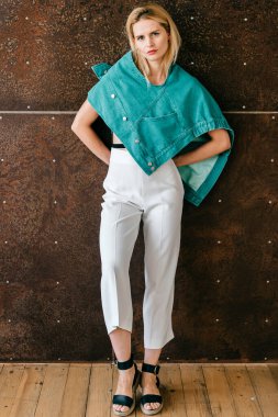 Stüdyoda poz veren şık elbiseli güzel sarışın manken.