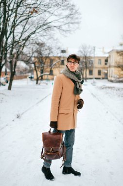 Şehir sokaklarında poz veren şık elbiseli yakışıklı bir adamın hayat tarzı portresi.