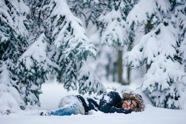 Yalnız adam karlı ormanda uyuyor. 
