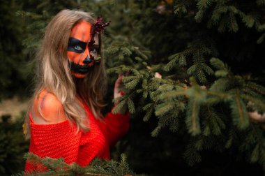 Cadılar Bayramı yüzlü genç sarışın kız dışarıda poz veriyor. Helloween kutlama konsepti.