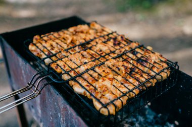 Izgarada iştah açıcı beyaz et. Açık havada ızgarada et kebabı. Lezzetli et yemeği orman turisti. Sokakta ızgarada yemek yanıyor