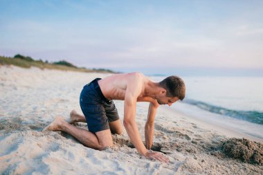 Kumsalda çukur kazan adam.