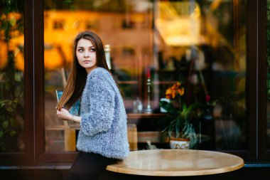 Marketin önünde sabahları soyut yansımalarla kameraya poz veren duygusal düşünceli genç ve güzel bir manken kız. İnanılmaz genç bayan mavi gözlü ruh hali portresi