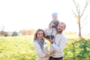 Mutlu aile aktiviteleri. Genç duygusal ebeveynler güneşli bir günde çocuklarıyla oynuyorlar.