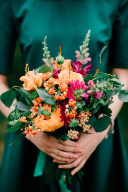 Yeşil şık elbiseli, genç, güzel, seksi bir kız. Açık hava yaz hayat tarzı portresi. Elinde bir buket çiçek olan alışılagelmedik bir genç. Oldukça neşeli çıplak ayaklı bir kadın doğada boş vakit geçiriyor.