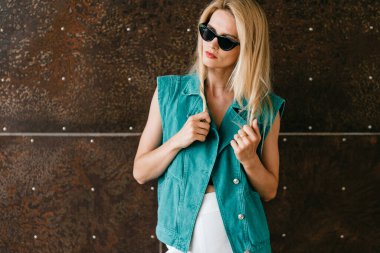 Stüdyoda poz veren şık elbiseli güzel sarışın manken.