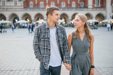 Krakow 'daki merkez meydanında genç ve sevgi dolu bir çift kucaklaşması.)