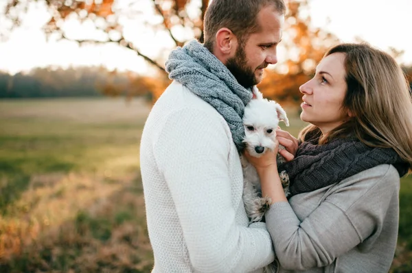 Romantic couple with funny pet  portrait at nature.