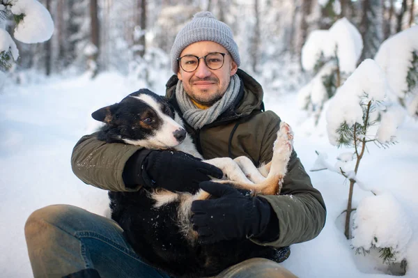 Счастливый Человек Держит Руках Прекрасную Собаку Снежном Лесу Улыбающийся Мальчик — стоковое фото
