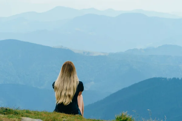 年轻姑娘在山顶上悠闲地欣赏风景 美丽的夏季自然景观 年轻寂寞的金发少女旅行者在户外度假时做梦 浪漫的心情 — 图库照片