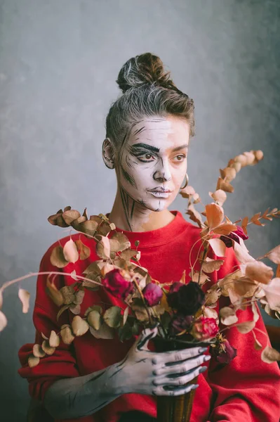 創造的な図面を持つ美しい若い女性1彼女の顔 漫画の骨格 背景にグランジの壁に乾燥した装飾の花と花瓶を保持 — ストック写真