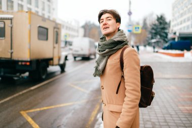 Şehir sokaklarında poz veren şık elbiseli yakışıklı bir adamın hayat tarzı portresi.