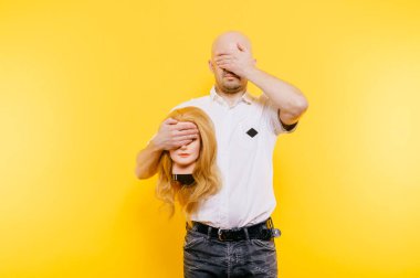 Heyecanlı, tuhaf, tuhaf, tuhaf, tuhaf, üzgün, kel, kel, plastik, sarışın kadın kafası tutan bir adam. Sarıda izole edilmiş kız arkadaşı olan komik bir erkek. Kemoterapiden sonra kellik. Kanser saç dökülmesi konsepti