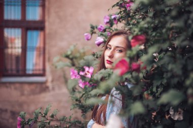 Güzel, genç bir manken. Şehvetli bir yüzü var. Çiçeklerle pusuya yatmış.