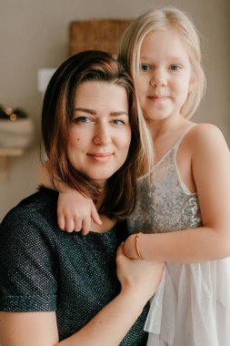 Anne ve kızı birbirlerine gülümseyen yüzlerle sarılıyorlar..