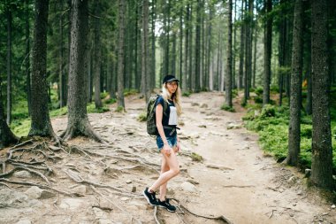 Genç, güzel sarışın bebek portresi. Sırt çantasıyla doğa gezisinde dağlarda yürüyüş yapan sevimli bir bayan gezgin. Kamp gezisindeki turist kadın. Tırabzanlara tırmanıyorum. Sıska stil kızı..