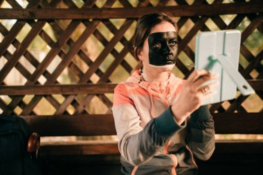 Yüzüne suluboya çizen genç bir makyöz..