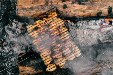 BBC 'de hazırlık. Soyut arka planda kavrulmuş etle dolu bir tabak. Kömürde sıcak, dumanlı barbekü yemeği ve yanmış odun. Açık havada ateş yakmak. Güzel kokulu yemek. Kızarmış çiklet parçaları.