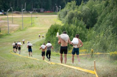 Omzunda ağır çantalarla dağdan aşağı inen bir grup genç insan. Atletlerden oluşan bir takım, sıcak mevsimde caddelerde pistin üstesinden geliyor. Engelli aşırı yarış. Modern dünyada spor kavramı