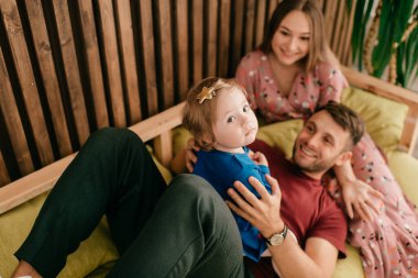 Güzel anne ve güçlü baba yalan söyler ve tatlı küçük kızlarıyla oynarlar.