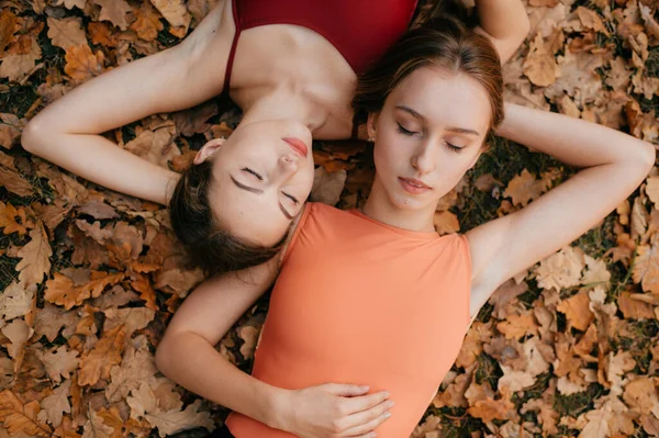 Dos Chicas Jóvenes Tumbadas Hojas Otoño —  Fotos de Stock