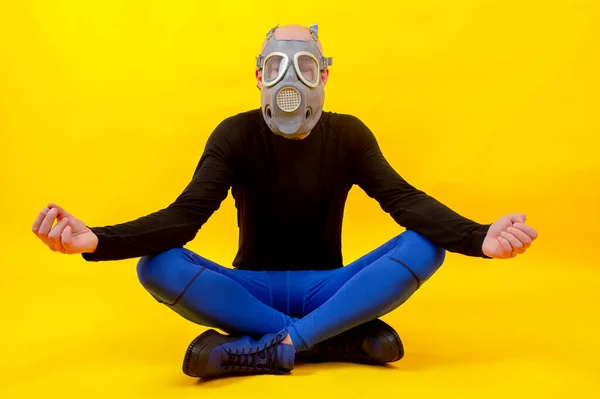 一个奇怪的男人坐在呼吸器里 在黄色的背景下摆出瑜伽姿势 — 图库照片