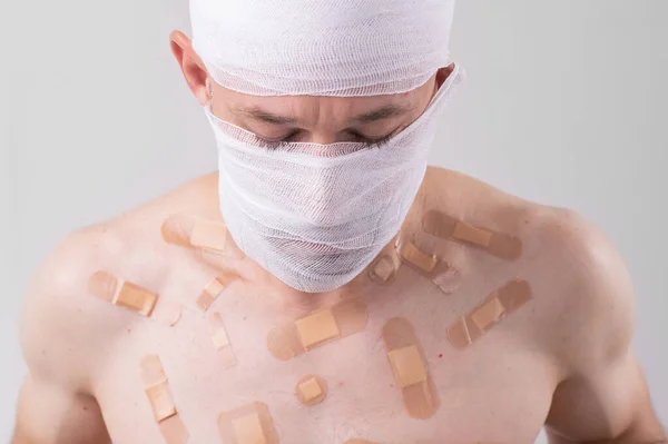 Τραυματίας Άνθρωπος Πολλά Μπαλώματα Στο Σώμα Του Και Δεμένο Κεφάλι — Φωτογραφία Αρχείου