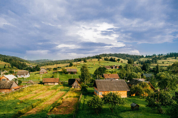 Countryside rural nature landscape in summer sunny day. Discover Ukraine. Village in Carpathians mountains. Beautiful scenic view at green hills and rustic terrain. Fairy tale magic beauty of nature