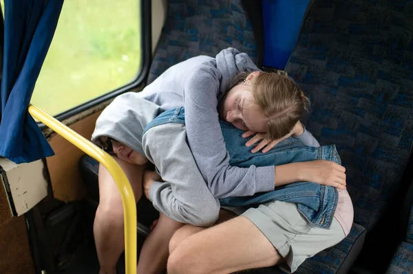 Loving couple sleeping and hugging in bus.