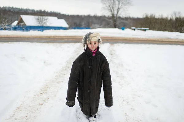 Klein Vrolijk Meisje Oversized Gewatteerde Jas Staan Besneeuwde Weg Winter — Stockfoto