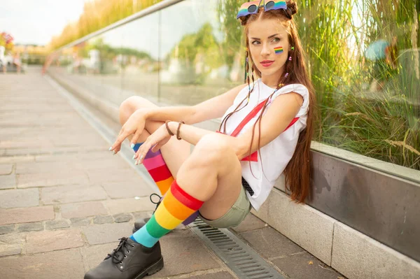 Stylowy Model Lesbijki Flagą Lgbt Twarzy Siedzi Pobliżu Szklanej Ściany — Zdjęcie stockowe