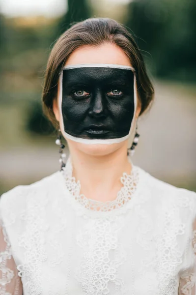 一个穿着老式白色衣服 脸上涂着黑色方块的成年女子的画像 创意面部艺术 — 图库照片