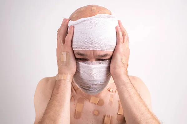 Injured Man Many Patches His Body Bandaged Head Isolated White — Stock Photo, Image