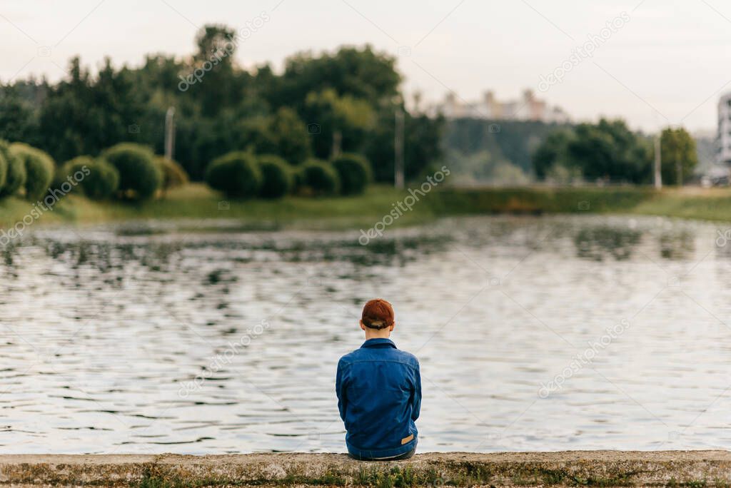 Barefoot lonely adult man sitting on edge of embankment outdoor. Homeless poor person in depression. Waiting for help. Problematic life. Psychological dramatic male portrait. Friendless person.